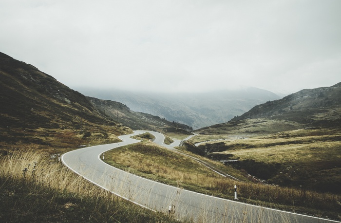Winding mountain road through misty landscape
