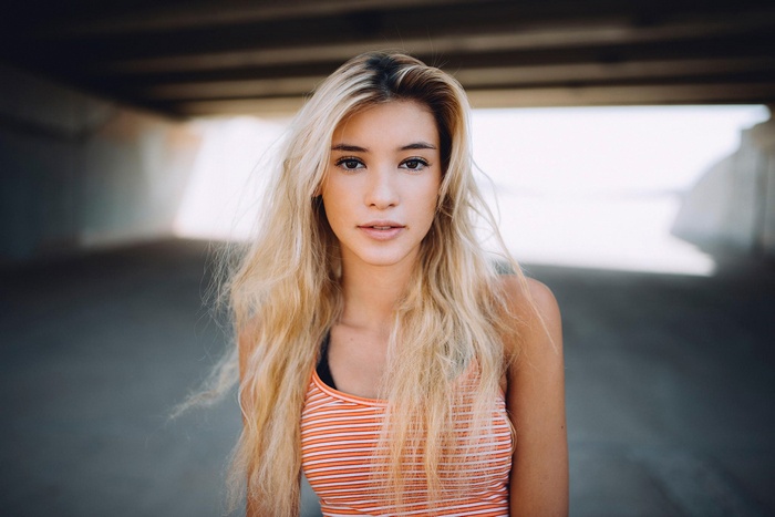 Portrait of a blonde woman in an orange striped tank top
