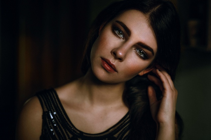Woman with green eyes and dark hair in a black dress