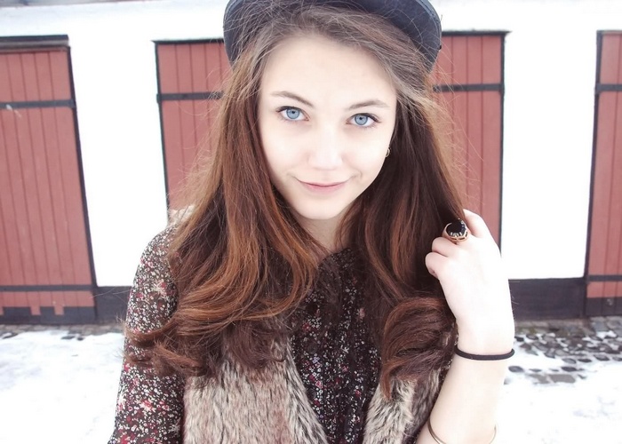 Woman with blue eyes and brown hair wearing a hat