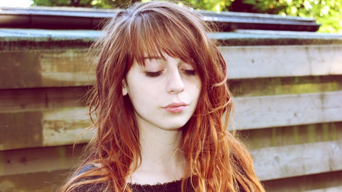 Woman with long auburn hair and bangs