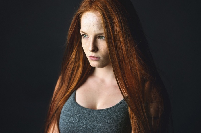 Redhead woman with freckles looking away
