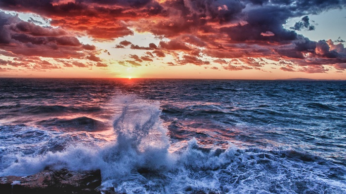 Sunset over the sea with crashing waves
