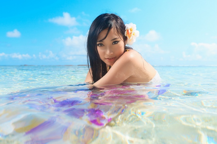 Woman with flower in hair in the ocean