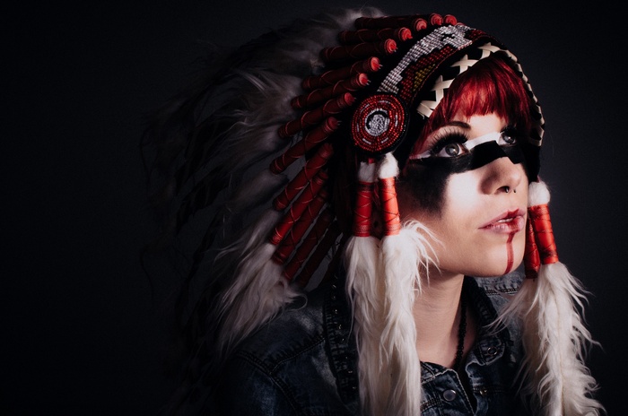 Woman wearing a Native American headdress and face paint