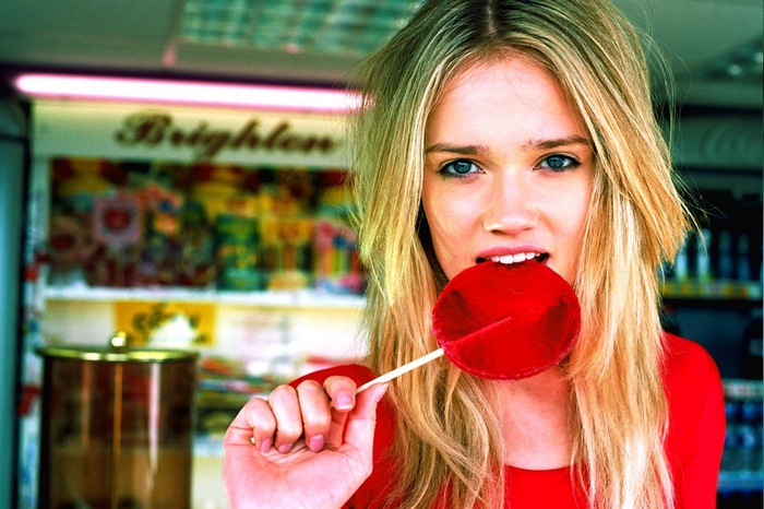Florrie biting a red lollipop
