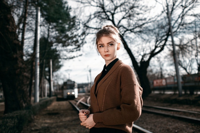 Woman with black fingernails by train tracks