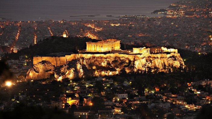 The Acropolis of Athens illuminated at night overlooking the city