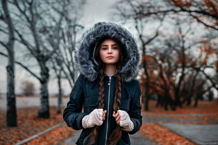 Woman in a fur-hooded jacket in autumn park