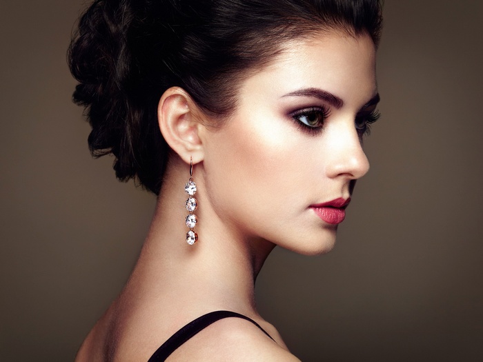 Woman with dark hair and diamond earrings