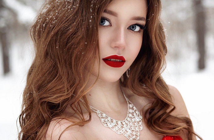 Woman with red lipstick and necklace in snow