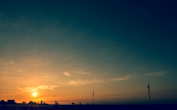 Wind turbines at sunset over a field