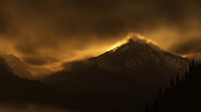 Golden light illuminates a majestic mountain peak.