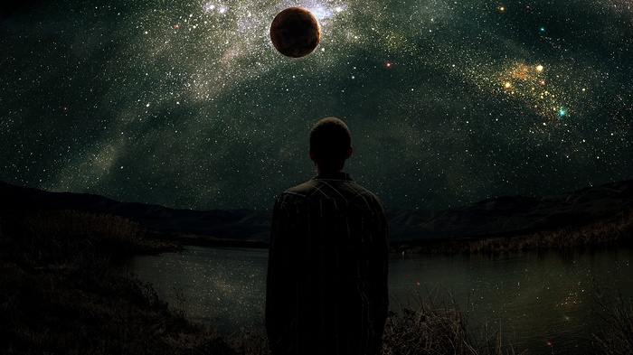 Man looking at a planet in a starry sky