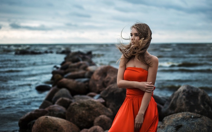 Woman in red dress by the sea