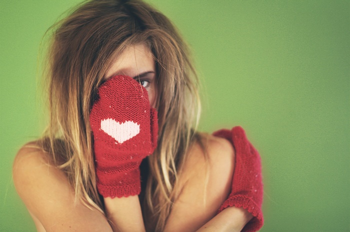 Woman wearing red mittens with heart