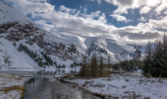 Winter mountains landscape with a frozen lake
