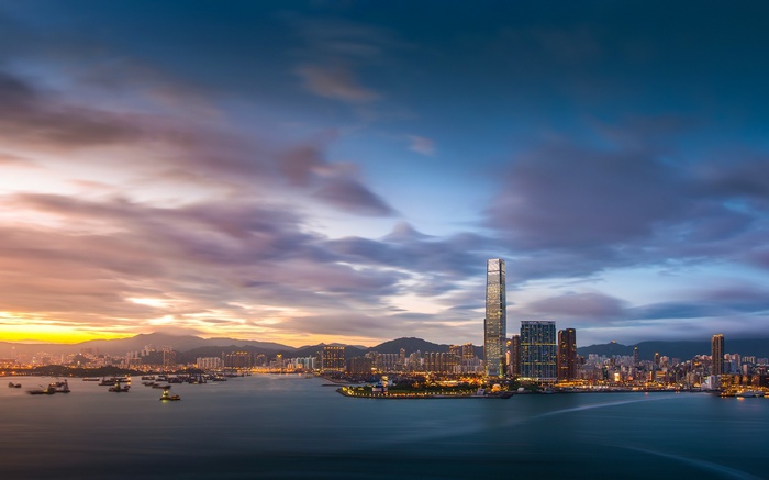Hong Kong cityscape at sunset with skyscrapers and harbor