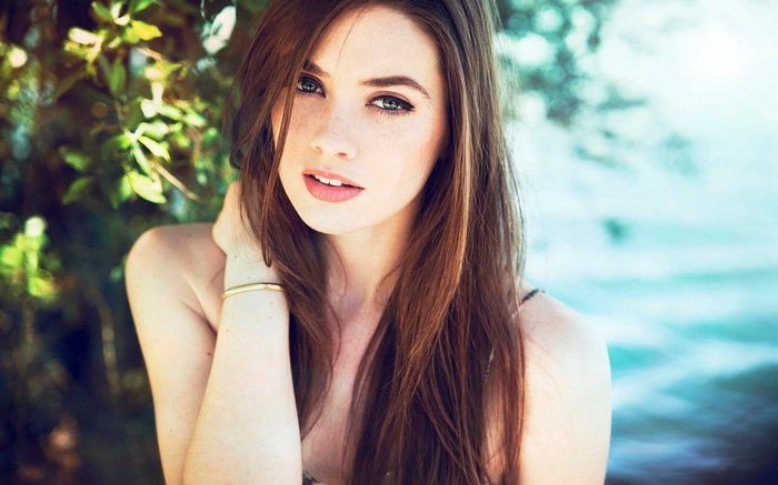 Woman with long brown hair and bare shoulders