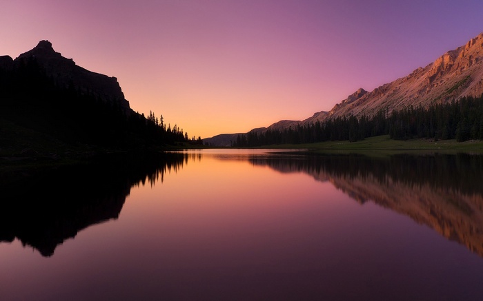 Sunset over a mountain lake with reflections