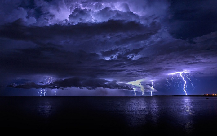 Lightning strikes over the ocean during a storm