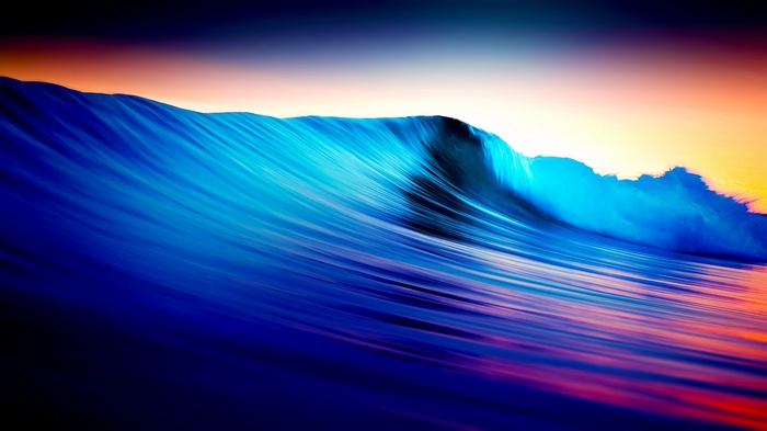 Long exposure of a colorful ocean wave at sunset