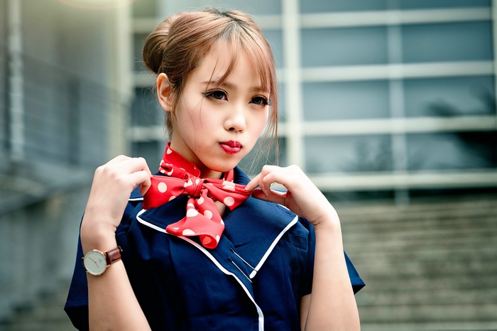 Asian woman with auburn hair wearing a red polka dot scarf
