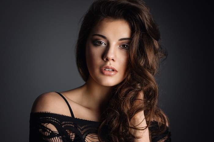 Woman with dark wavy hair and makeup
