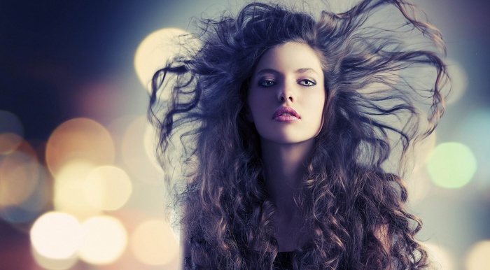 Woman with long curly hair and bokeh background