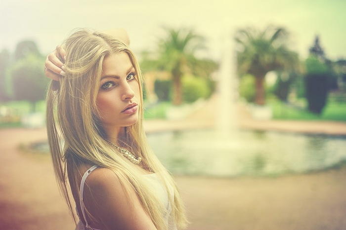 Woman with blonde hair and pearl necklace outdoors