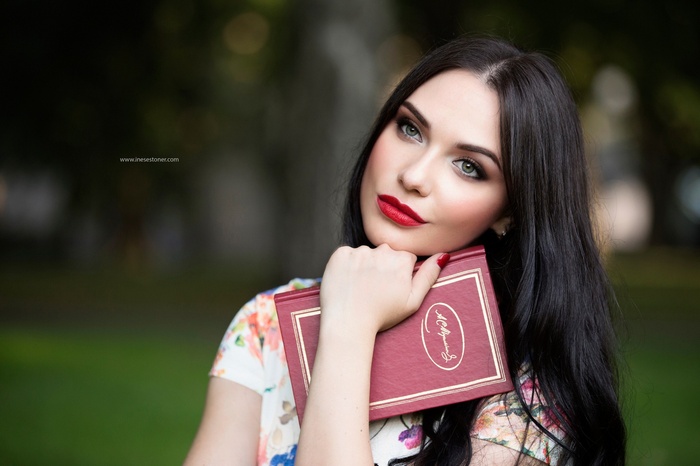 Woman with red lipstick holding a book