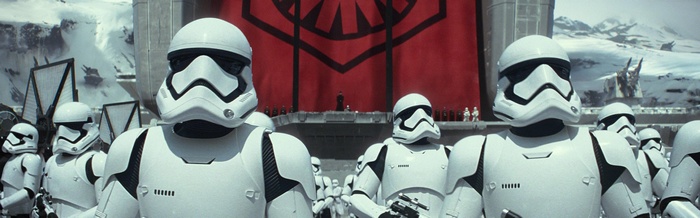 First Order Stormtroopers stand before a large red banner