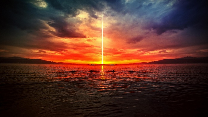 Dramatic sunset over the ocean with a light beam