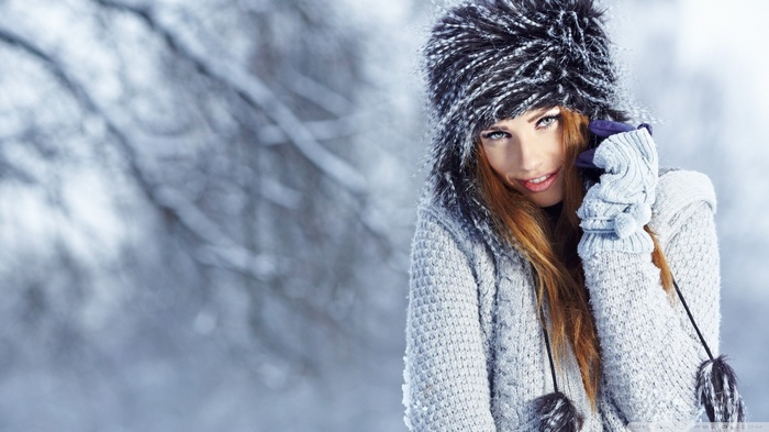 Woman in winter hat and sweater in snow