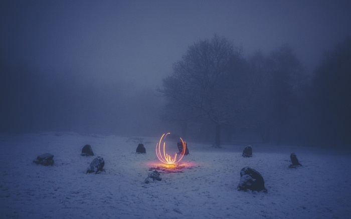 Winter scene with glowing orb and standing stones