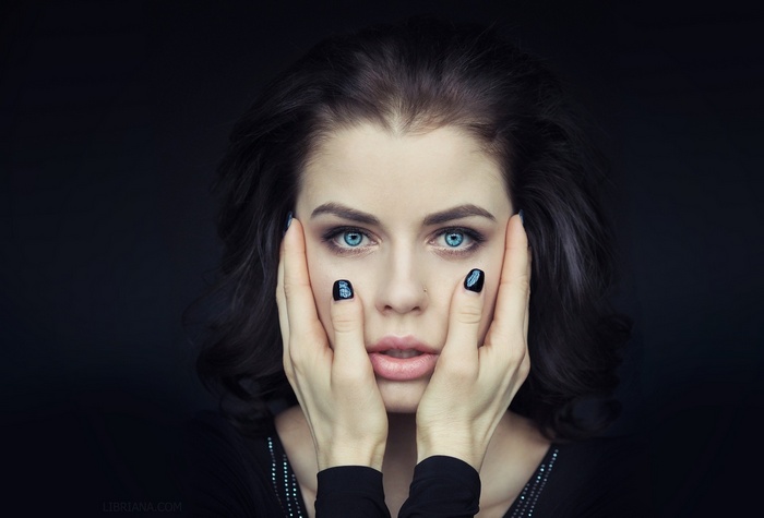 Woman with blue eyes and black painted nails