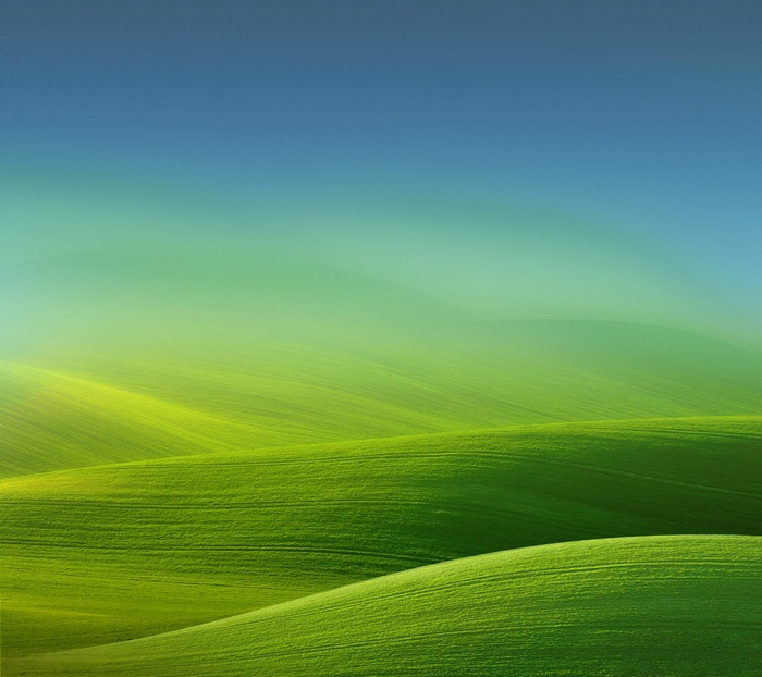 Green rolling hills under a blue and green gradient sky