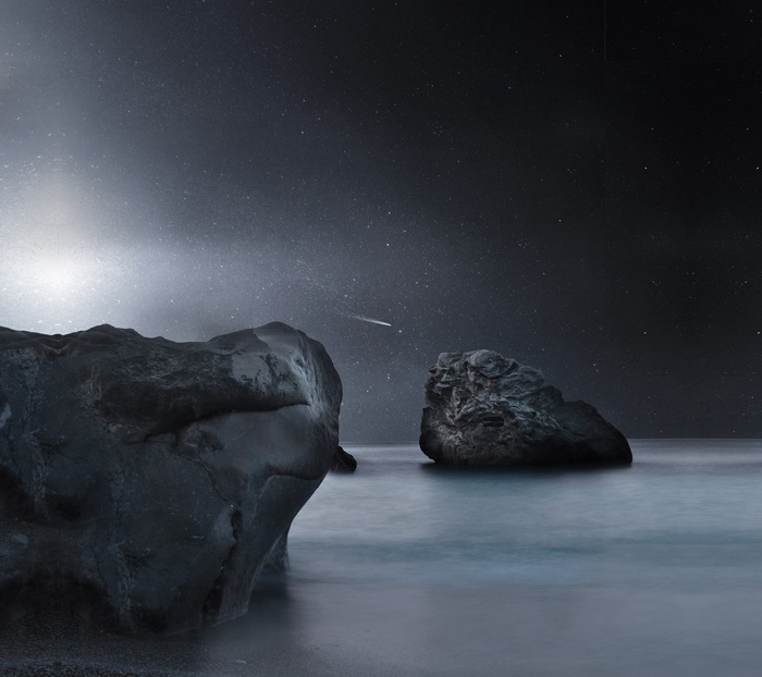 Rocks in the ocean under a starry sky