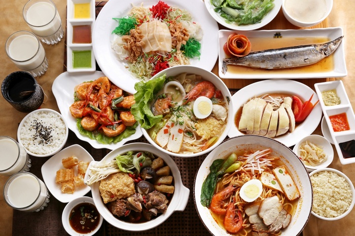A spread of Asian dishes including seafood, chicken, and noodles