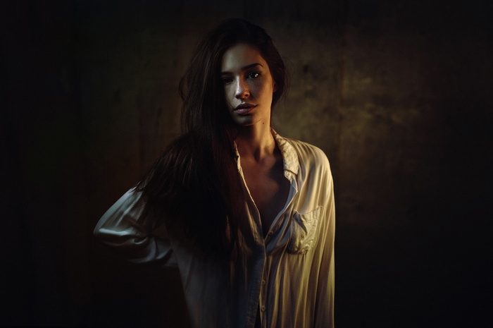 Woman in a white shirt in dim lighting