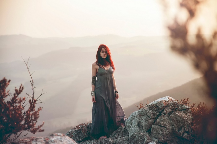 Woman with red hair in a dress on a mountain