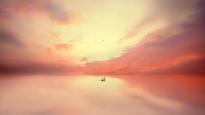 A lone person on a boat in the sea at sunset