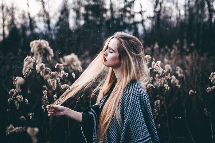 Woman with blonde hair in a field of dry plants
