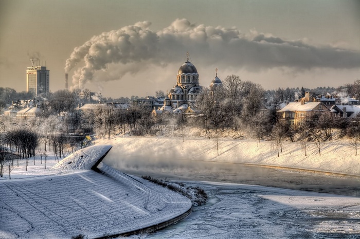 Winter cityscape of Lithuania with a frozen river and cathedral