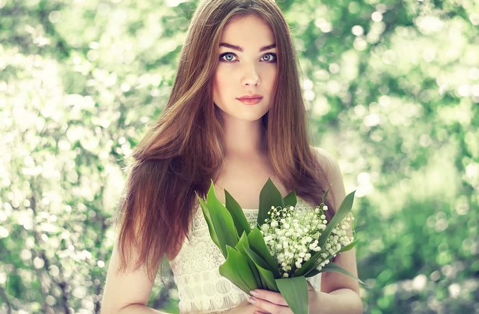 Woman holding a bouquet of lily of the valley flowers