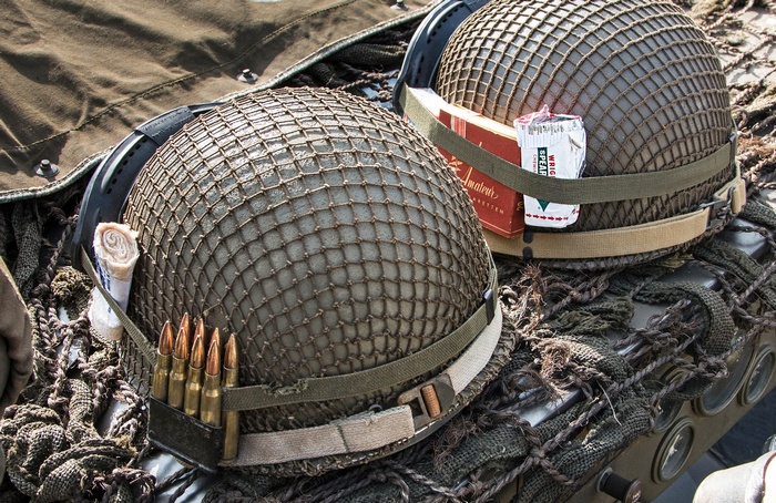 Two military helmets with ammunition and cigarettes