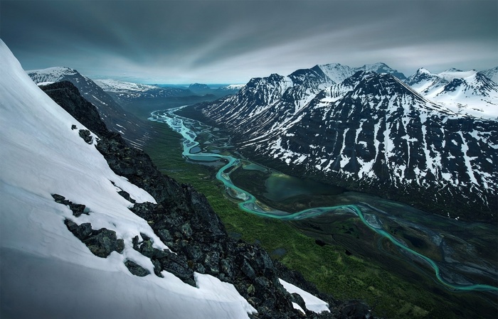 Snowy mountains and a turquoise river valley in Sweden