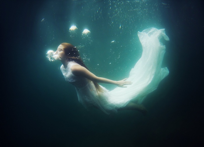 Woman in white dress underwater