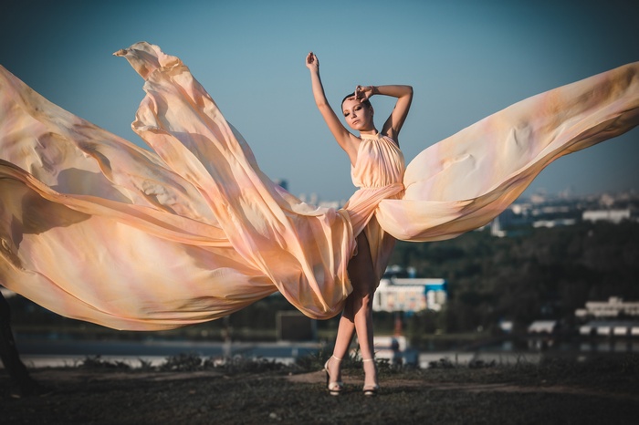 Woman in flowing peach dress on a hill