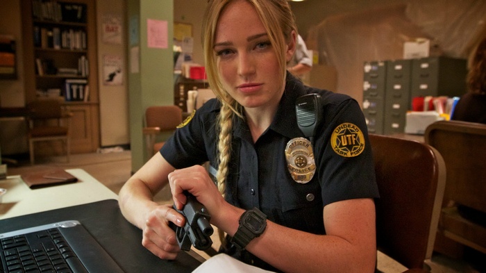 Caity Lotz as a police officer with a gun